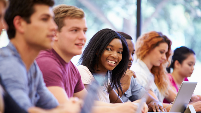 Students with laptops sitting in a row